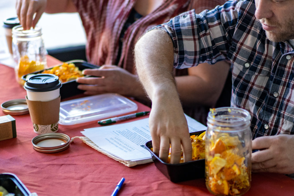 An image of people filling jars with herbs during a workshop
