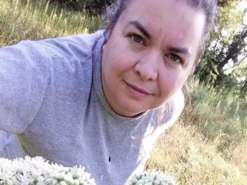 Amy Shea with a bunch of boneset flowers in the foreground
